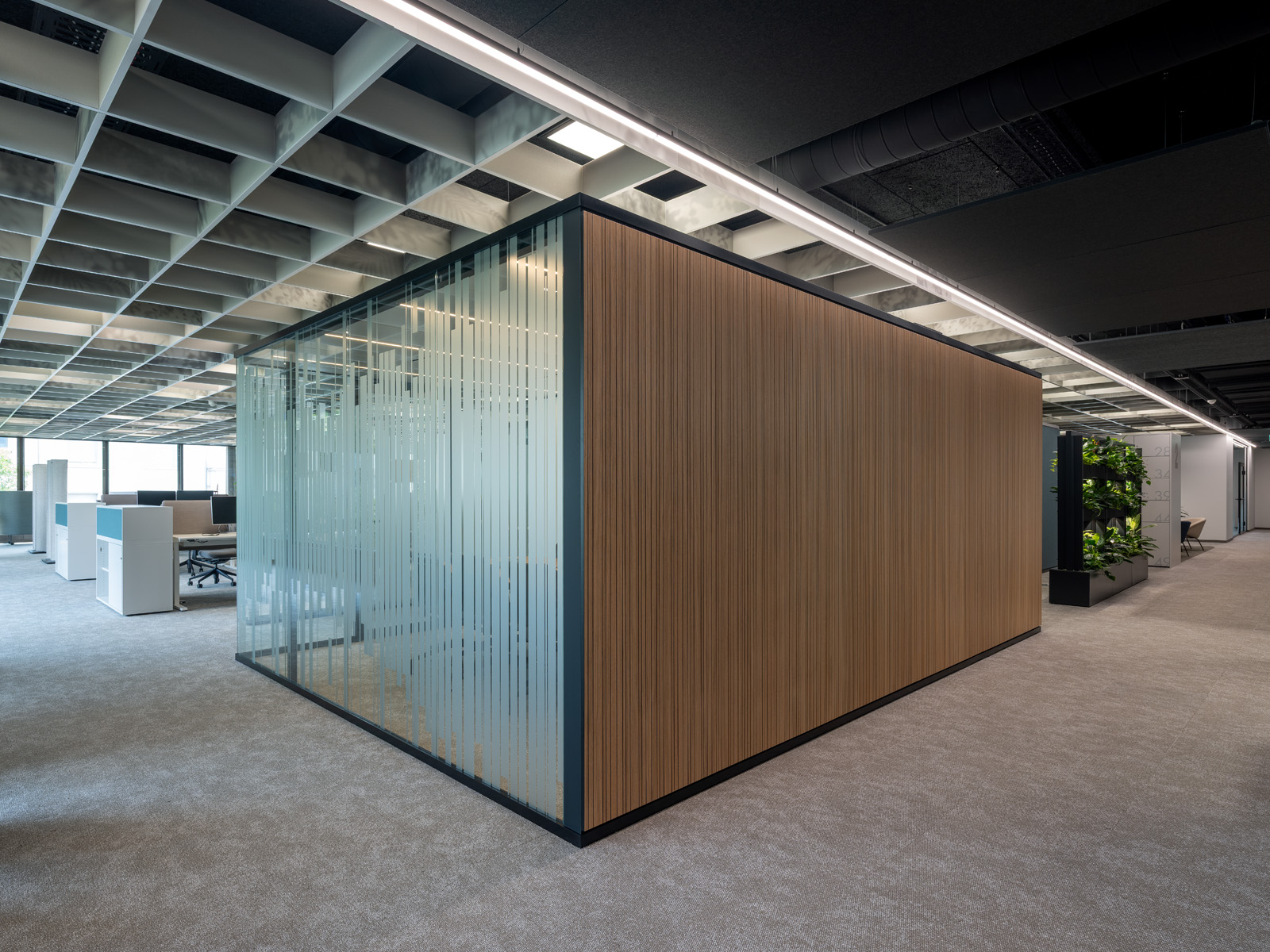 Raum-in-Raum-Systeme im Open Office mit bedruckten Glas und Stoffbespannung petrolfarbend außen. 