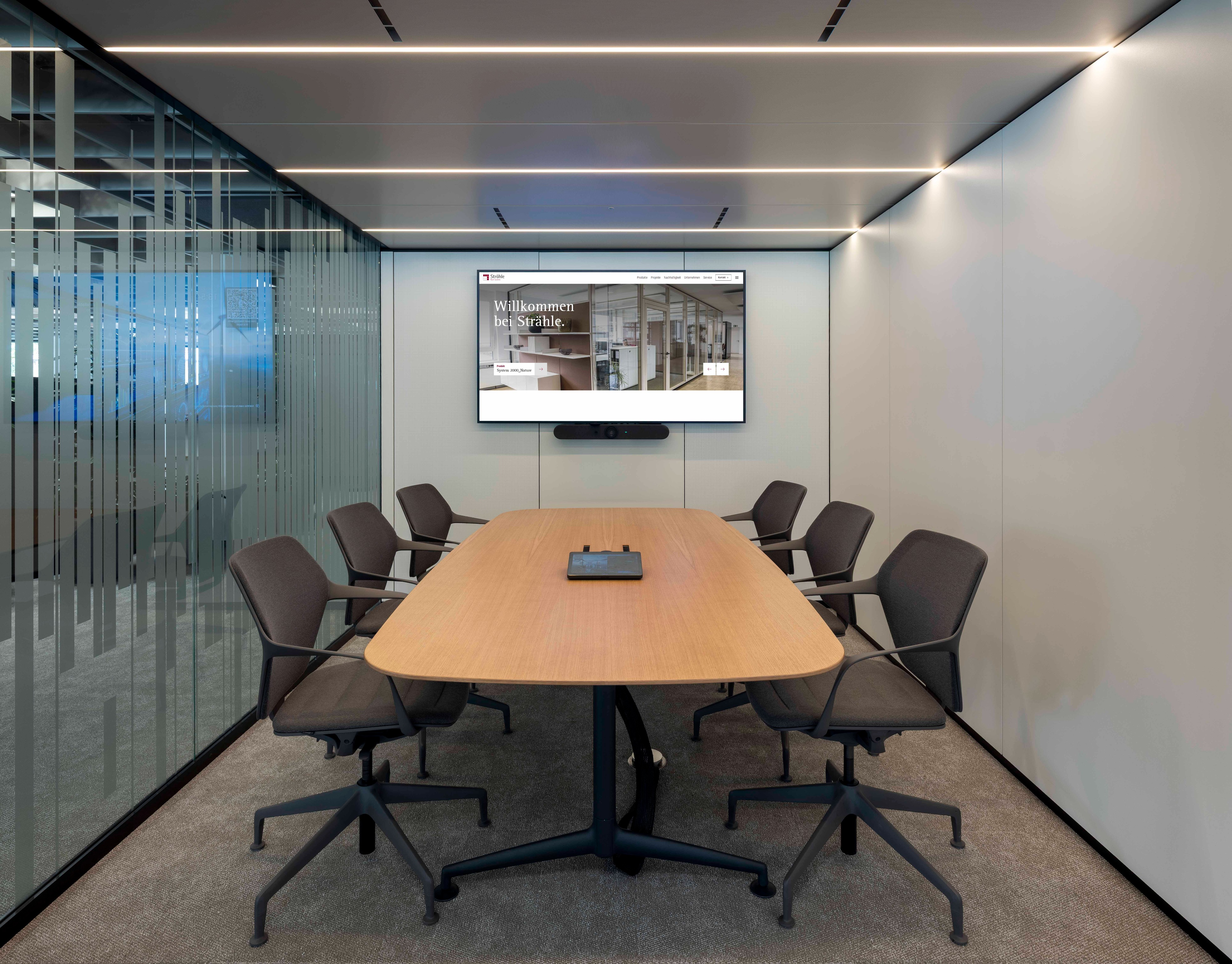 Raum-in-Raum-Systeme im Open Office mit bedruckten Glas und Stoffbespannung petrolfarbend außen. 