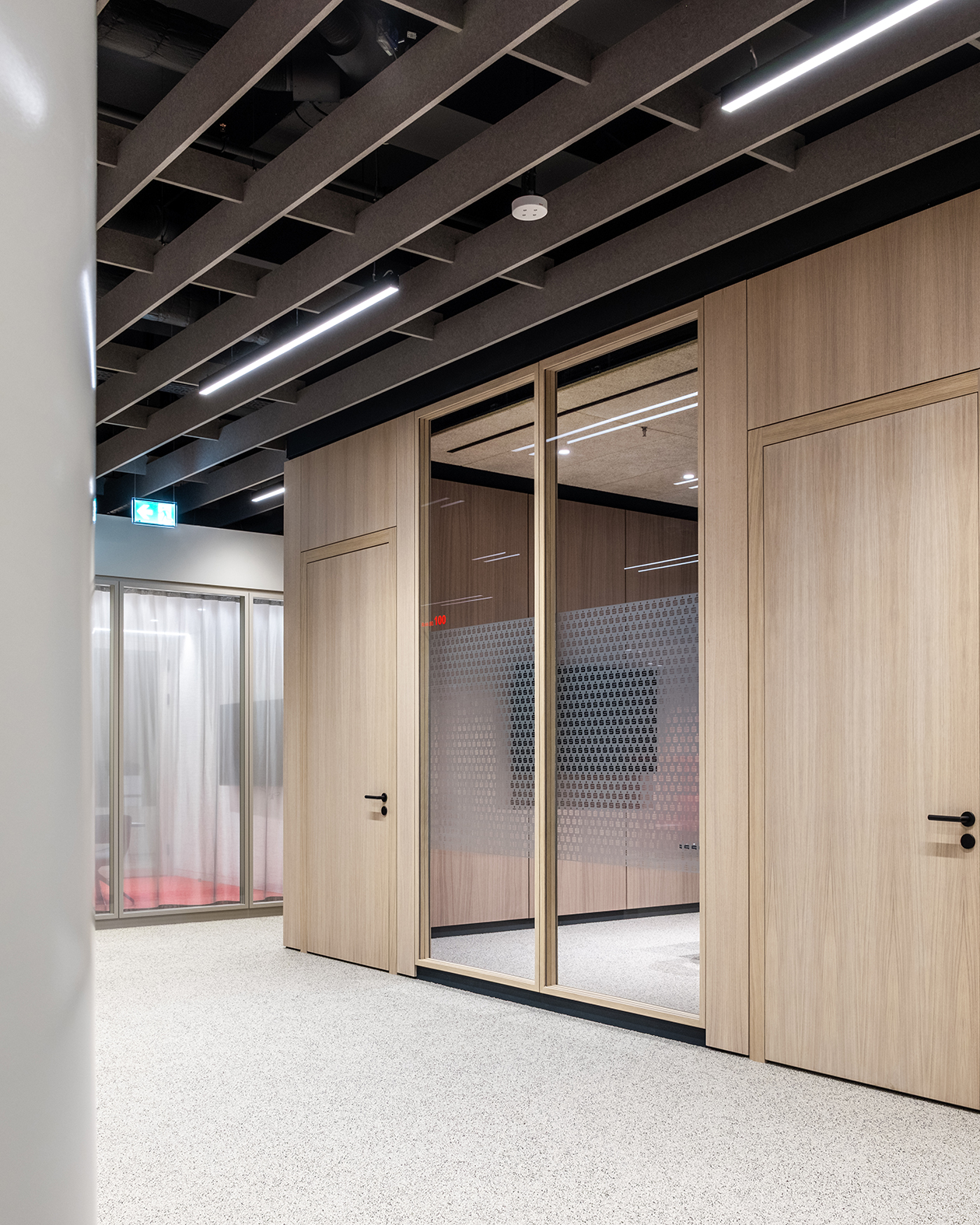 Büroflächen mit Trennwandsystemen mit furnierten Holzoberflächen. Ganzglaswände und Volltüren sowie Besprechungsräume.