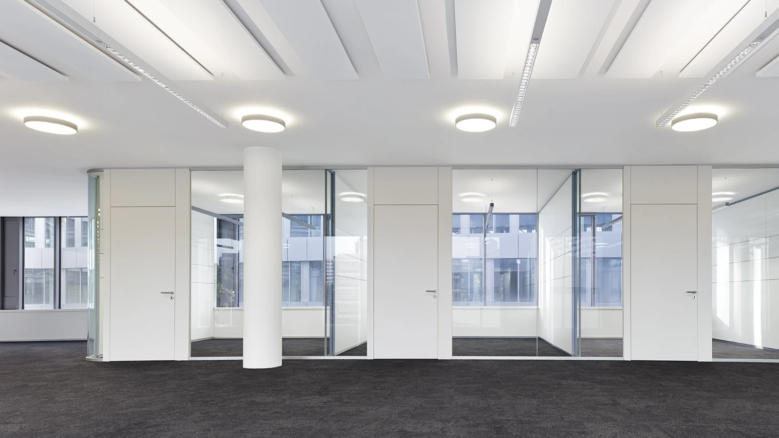 Heller, moderner Konferenz- oder Büroflur mit Glasverglasung, weißer Architektur und minimalistischer Beleuchtung.