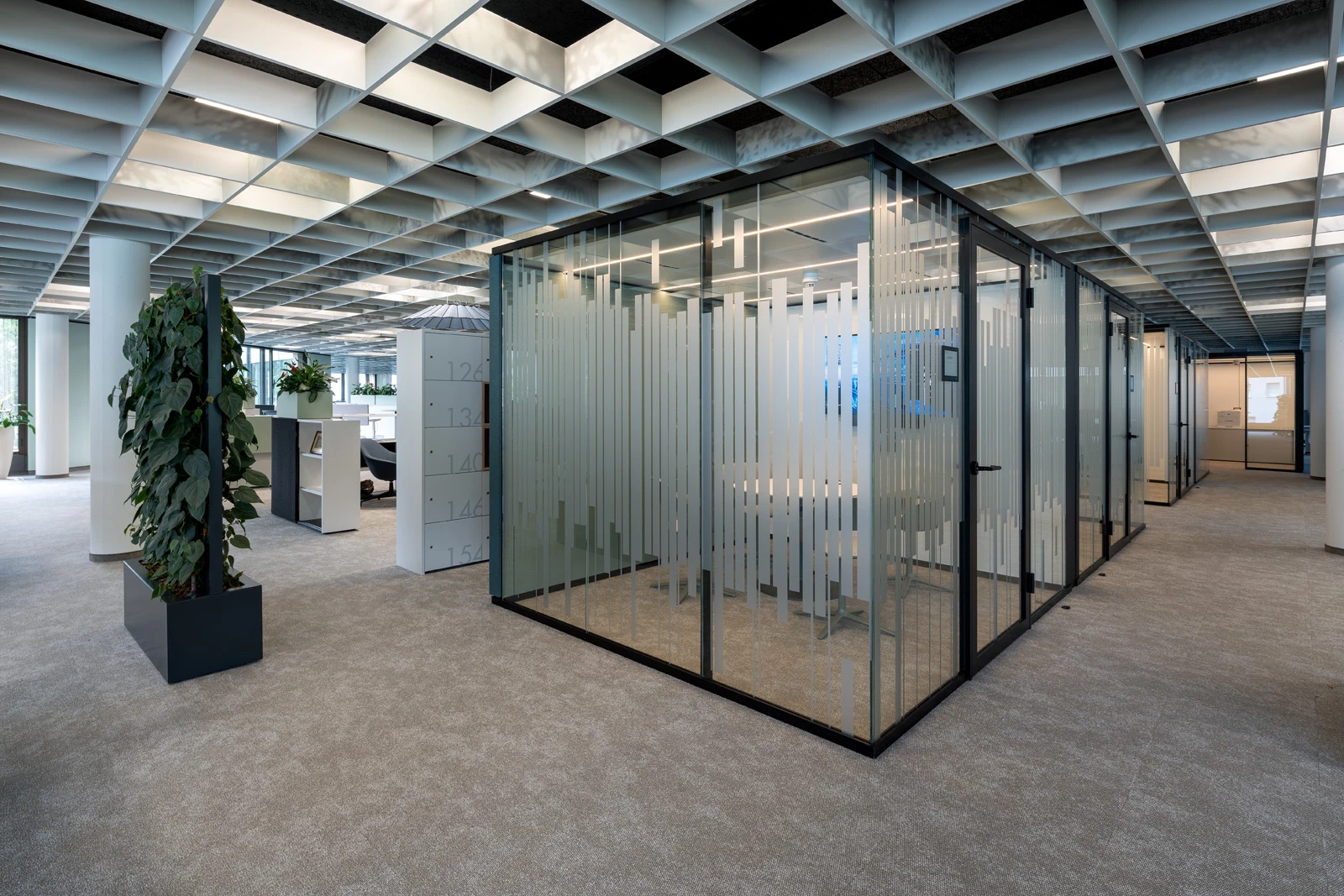 Raum-in-Raum-Systeme im Open Office mit bedruckten Glas und Stoffbespannung petrolfarbend außen. 