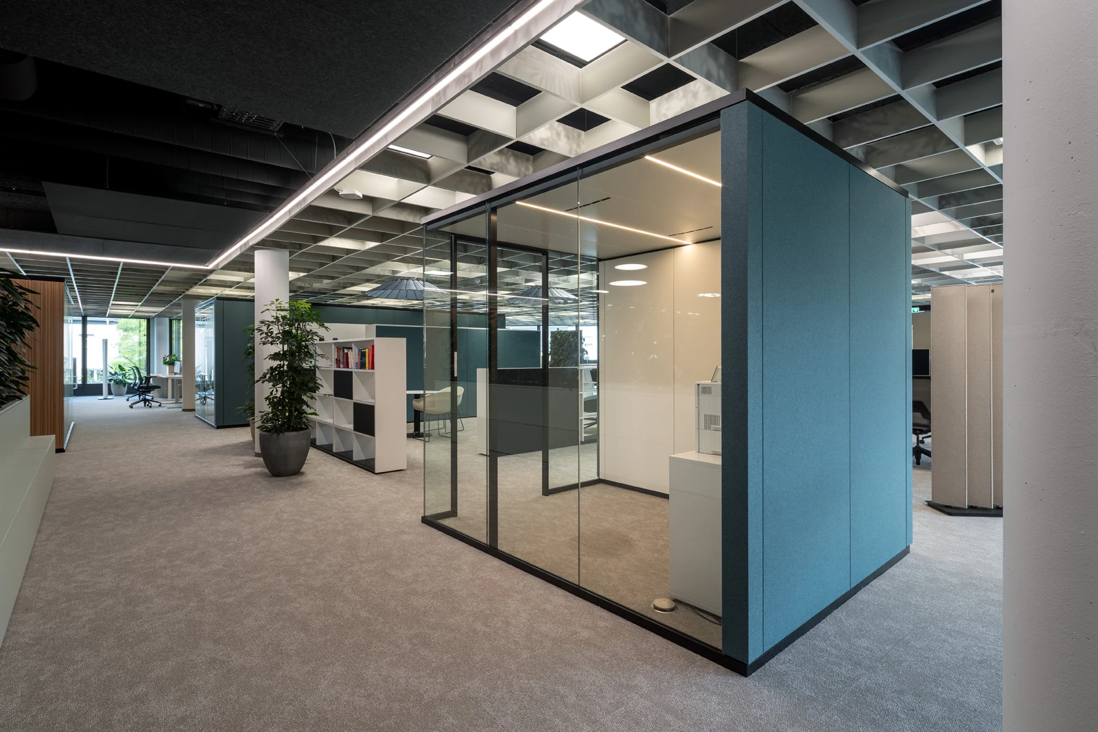 Raum-in-Raum-Systeme im Open Office mit bedruckten Glas und Stoffbespannung petrolfarbend außen. 