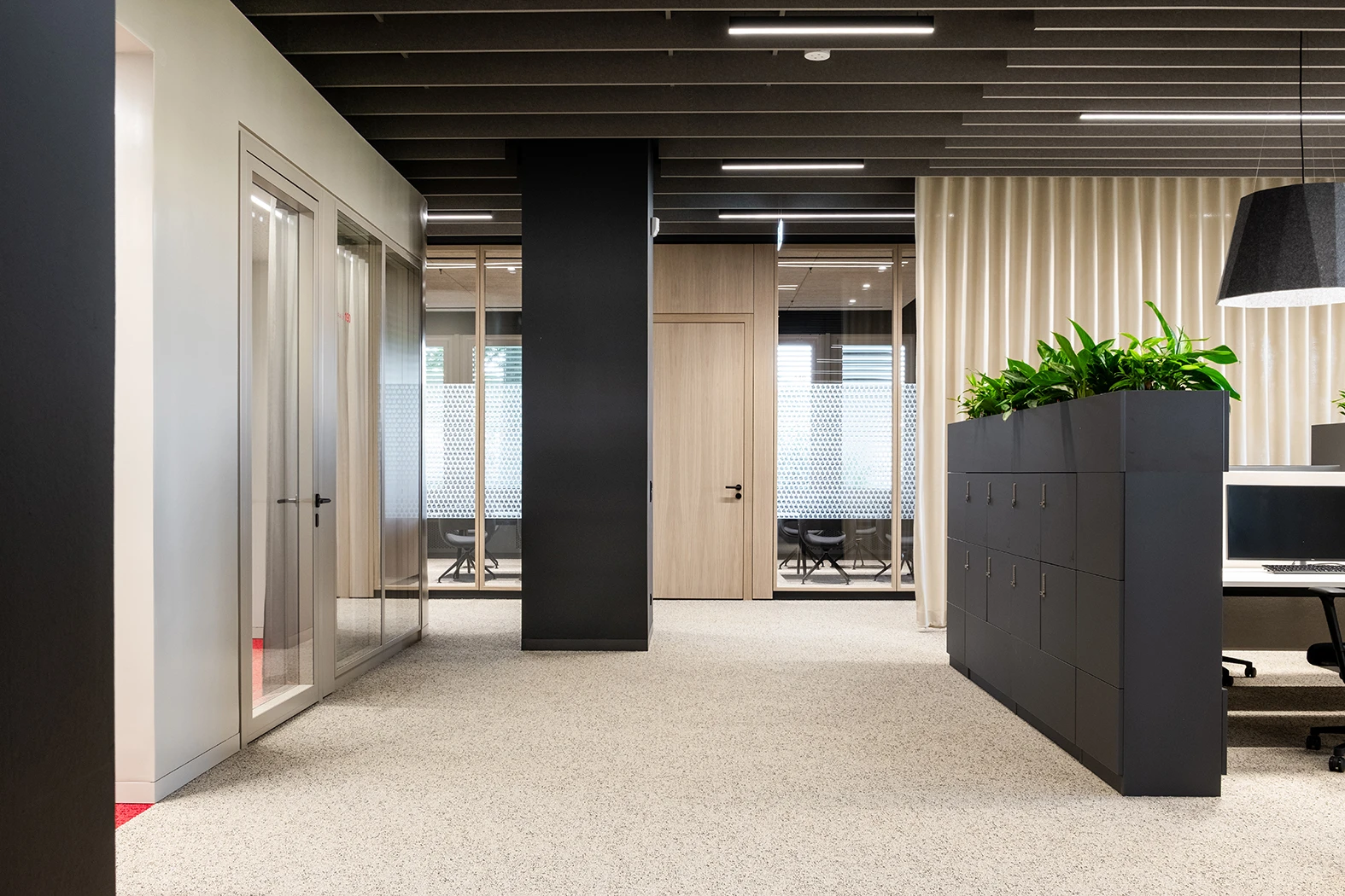 Büroflächen mit Trennwandsystemen mit furnierten Holzoberflächen. Ganzglaswände und Volltüren sowie Besprechungsräume.