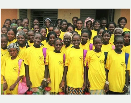 Viele lächelnde Schüler in gelben T-Shirts bei einem Schulprojekt in Burkina Faso.